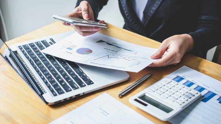 Businesswoman accountant working analyzing and calculating expense financial annual, financial balance sheet statement and analyze document graph and diagram, doing finance making notes on report.