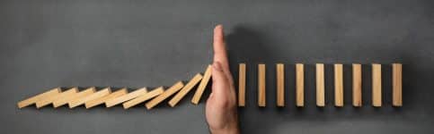 Chain Reaction In Business Concept, Businessman Intervening Dominoes Toppling